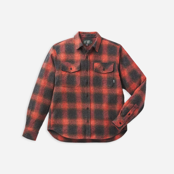 A long-sleeve button-up flannel shirt in a red and black buffalo plaid pattern, featuring two buttoned chest pockets, displayed on a light gray background.