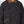 Load image into Gallery viewer, Close-up of a black utility jacket with a brown corduroy collar and brown contrast stitching on the pockets, worn by a model.
