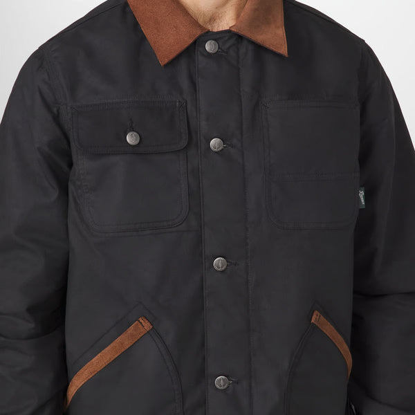 Close-up of a black utility jacket with a brown corduroy collar and brown contrast stitching on the pockets, worn by a model.
