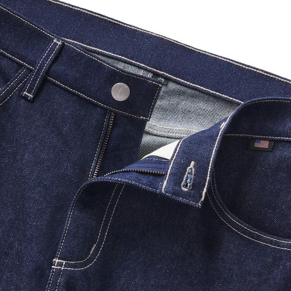 Close-up of blue denim jeans with a brand label on a white background