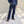 Load image into Gallery viewer, Person wearing blue jeans and a denim shirt standing in a room with sunlight casting shadows on the wall.
