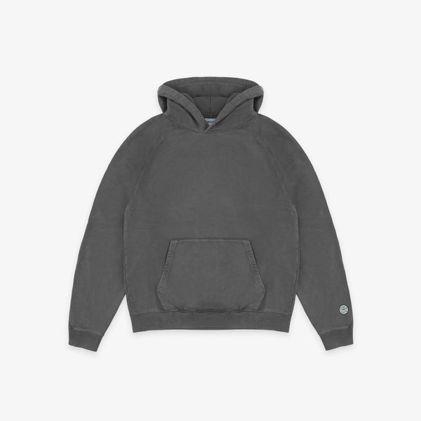 A dark gray washed cotton hoodie with a front kangaroo pocket and a small circular logo on the left sleeve cuff, displayed flat against a light gray background.
