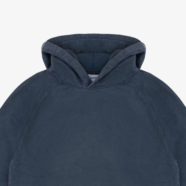 Close-up of a dark slate blue hooded sweatshirt showing the hood and upper chest area against a light gray background.