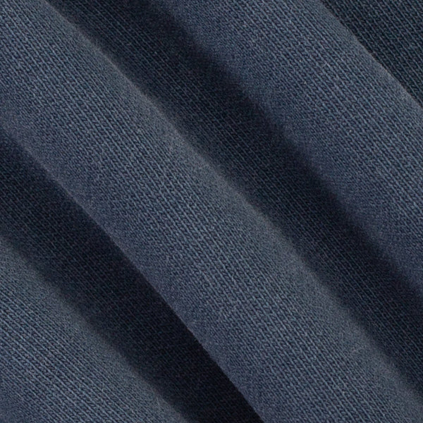 A close-up of dark navy blue textured fabric with soft diagonal folds showing the woven material detail.