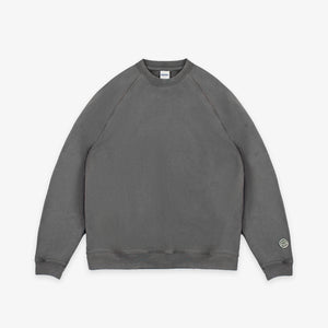 Dubbleware - Dubbleware Vintage Dye Sweatshirt - Washed Grey - A dark gray crewneck sweatshirt with raglan sleeves, laid flat against a light gray background. A small circular logo patch is visible on the left sleeve cuff. - Main Front View
