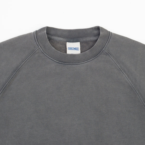 Close-up of a dark gray crewneck sweatshirt with raglan sleeves, showing the inner neck label with the brand name 'DIRTWEAR'.