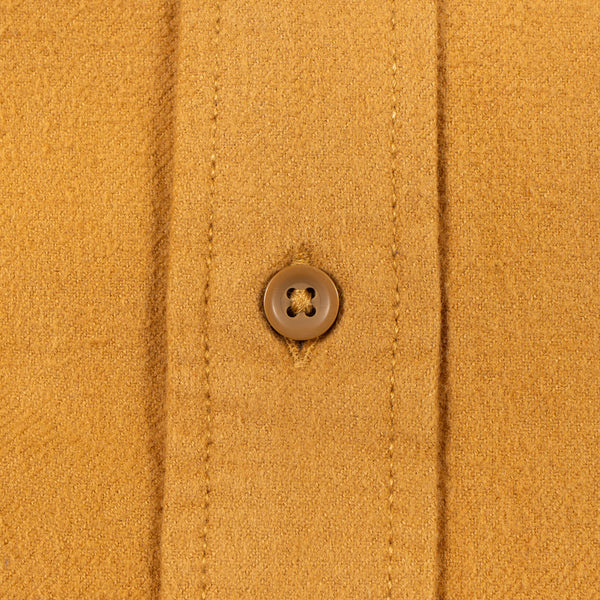 Close-up of a mustard yellow knit fabric garment with a single brown button on the front placket.