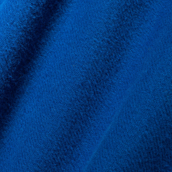 A close-up of textured royal blue fabric with soft folds and a woven or terry-like surface.