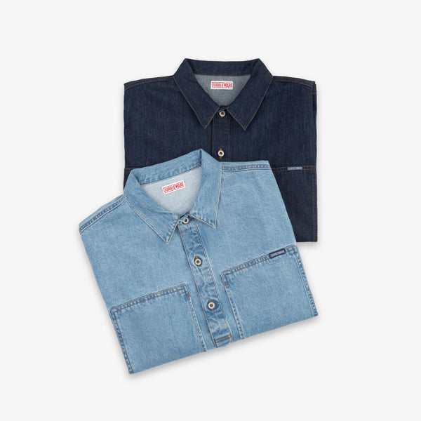 Two folded denim button-up shirts in light and dark blue washes, displayed on a clean white background. The brand name 'STOCKMAN' is visible on the inner neck labels.
