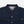 Load image into Gallery viewer, Close-up of a dark indigo denim button-up shirt by Dubble Wade, showing the collar, front buttons, chest pockets, and a small brand tag on the right chest pocket.
