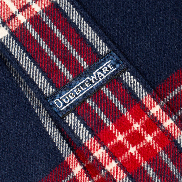 Close-up of a navy blue plaid fabric with red and white tartan pattern and a visible Dubbleware brand label.