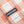 Load image into Gallery viewer, Close-up of a peach and white plaid fabric with a navy blue Dubbleware brand label sewn onto the side.
