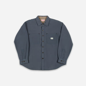 Dubbleware - Dubbleware Lined Snap Overshirt - Indigo Canvas - A dark slate blue long-sleeve button-up shirt with two chest pockets, laid flat against a light gray background. - Main Front View