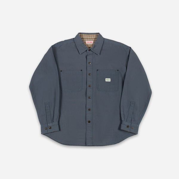 A dark slate blue long-sleeve button-up shirt with two chest pockets, laid flat against a light gray background.