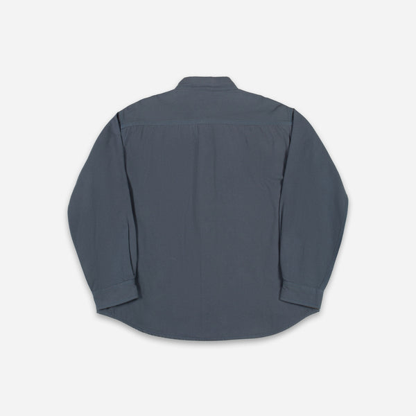 A dark slate blue long-sleeve button-up shirt shown from the back, laid flat against a light gray background.