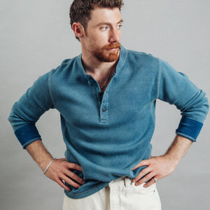 Double RL By Ralph Lauren - Jacquard Henley T-Shirt - Washed Blue Indigo - A man with a reddish beard wearing a textured blue long-sleeve henley shirt and off-white pants, posing with hands on hips against a solid gray studio background. - Alternative View 1
