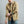 Load image into Gallery viewer, A man wearing a tan utility button-up shirt with a green undershirt, blue jeans, and a brown cap, posed against a solid gray studio background.
