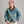 Load image into Gallery viewer, A man wearing a blue denim work jacket with a brown corduroy collar, paired with off-white trousers and a dusty pink baseball cap, photographed against a neutral gray studio background.
