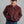 Load image into Gallery viewer, A man wearing a red, yellow, and blue plaid button-up overshirt jacket over a dark shirt and blue jeans, photographed against a plain gray studio background.
