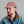 Load image into Gallery viewer, A man with a red beard wearing a dusty rose baseball cap with a circular blue, yellow, and white logo patch, paired with a blue denim shirt jacket with a brown corduroy collar, set against a plain gray background.
